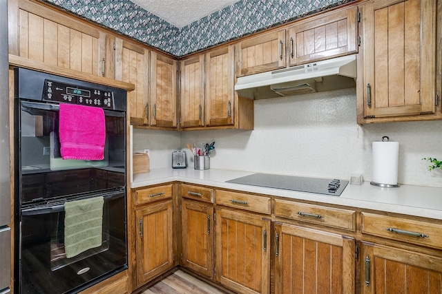 kitchen featuring black appliances and light wood-type flooring