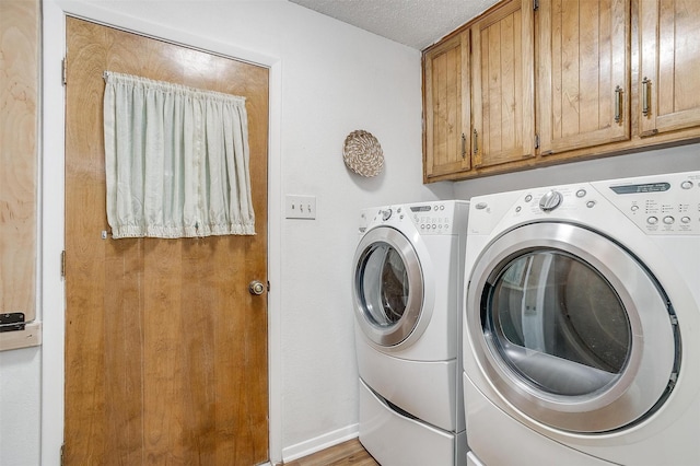 clothes washing area featuring independent washer and dryer, cabinets, a textured ceiling, and light hardwood / wood-style flooring