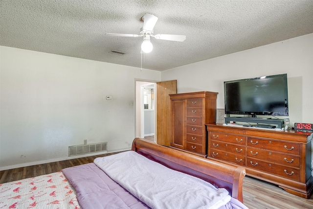 bedroom featuring ceiling fan, a textured ceiling, and light hardwood / wood-style flooring