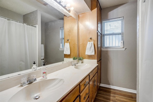 bathroom with wood-type flooring, a textured ceiling, and vanity