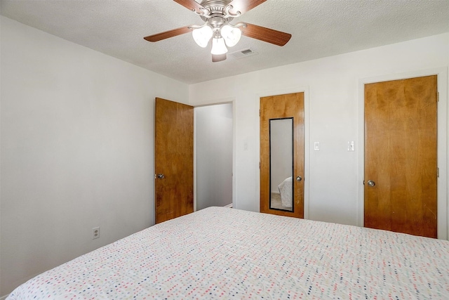 bedroom with ceiling fan and a textured ceiling