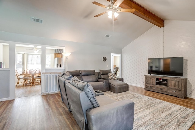 living room featuring light wood-type flooring, lofted ceiling with beams, and ceiling fan