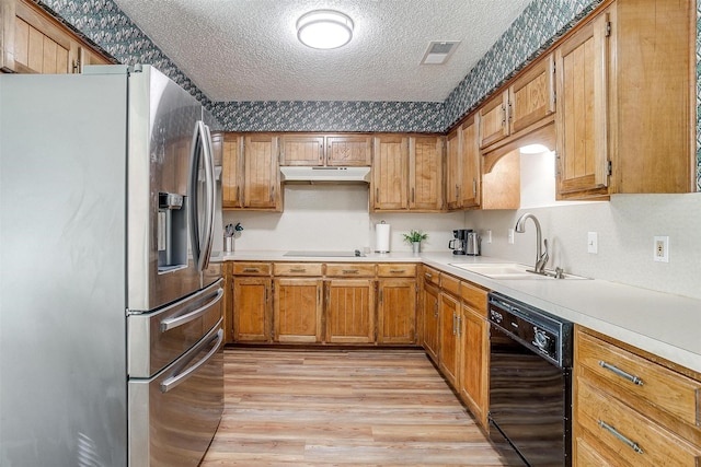 kitchen featuring black appliances, light wood-type flooring, a textured ceiling, and sink