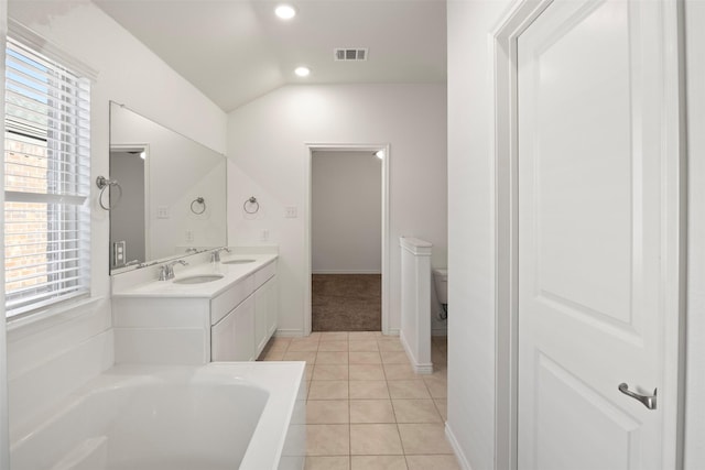 bathroom with a tub, toilet, a healthy amount of sunlight, and tile patterned flooring