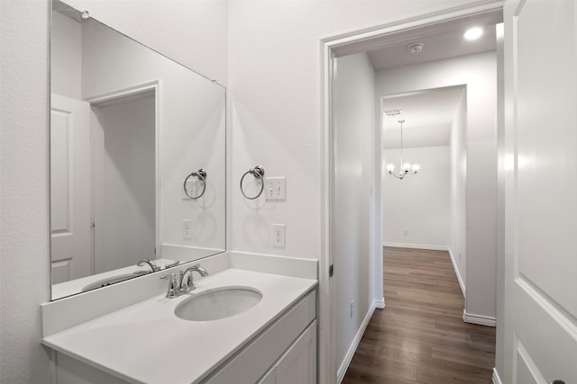 bathroom featuring wood-type flooring, vanity, and a chandelier