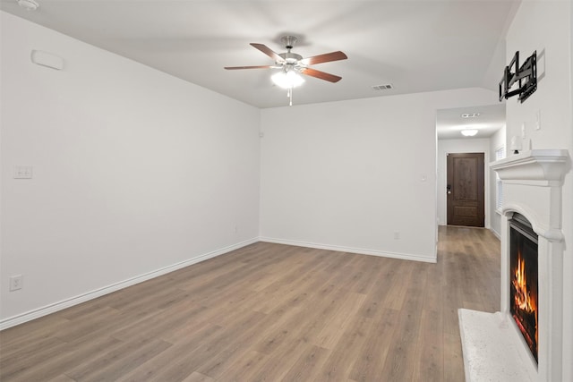 unfurnished living room featuring ceiling fan and light hardwood / wood-style floors