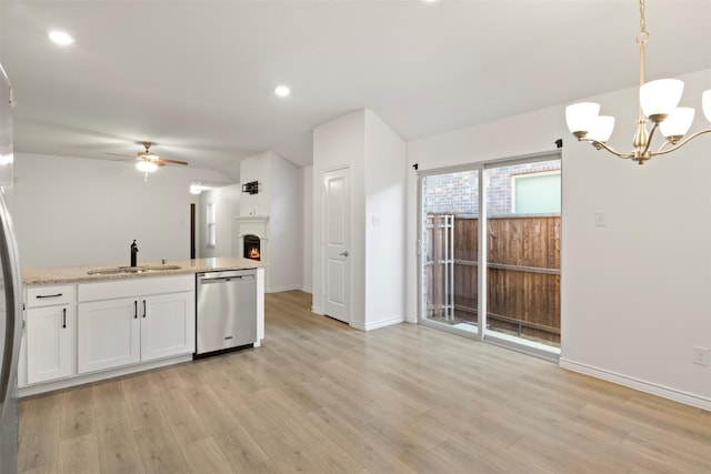 kitchen featuring ceiling fan with notable chandelier, white cabinets, decorative light fixtures, sink, and stainless steel dishwasher