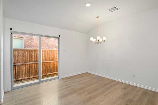 unfurnished room featuring vaulted ceiling, an inviting chandelier, and light wood-type flooring