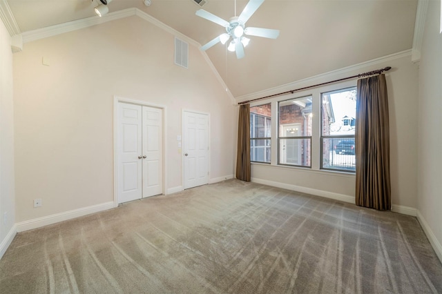 unfurnished bedroom with crown molding, ceiling fan, carpet floors, and two closets