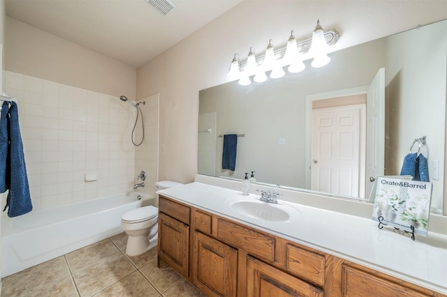 full bathroom featuring tiled shower / bath, vanity, toilet, and tile patterned flooring