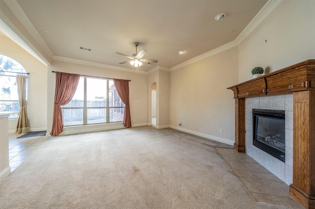 unfurnished living room with crown molding, ceiling fan, a fireplace, and light carpet