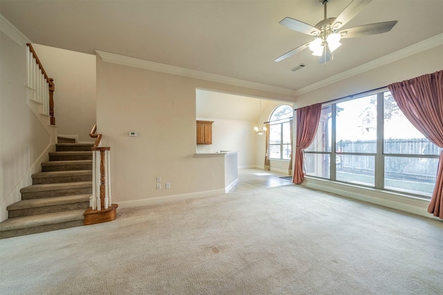 unfurnished living room with crown molding, ceiling fan with notable chandelier, a wealth of natural light, and light colored carpet