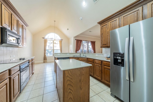 kitchen featuring lofted ceiling, sink, light tile patterned floors, a center island, and black appliances