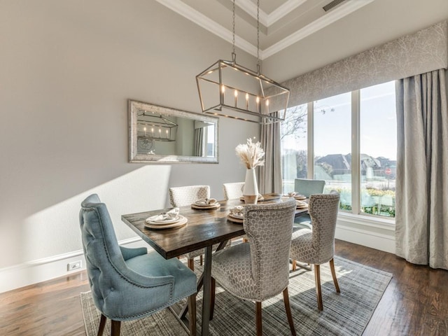 dining room with an inviting chandelier, ornamental molding, and dark hardwood / wood-style flooring