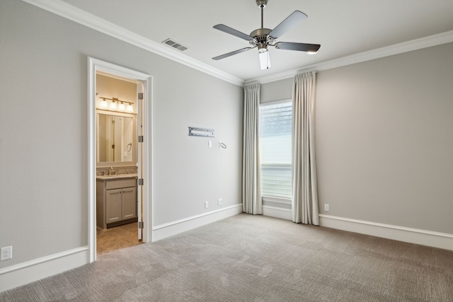 carpeted spare room featuring crown molding, plenty of natural light, and sink