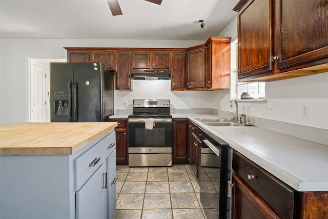 kitchen featuring ceiling fan, sink, a center island, black appliances, and wood counters