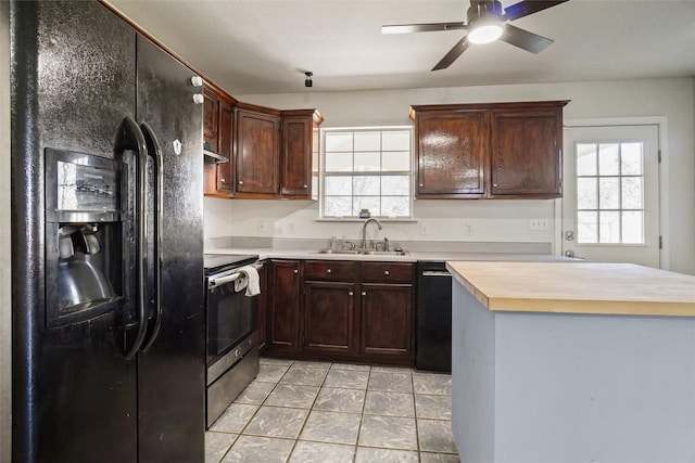 kitchen with black appliances, butcher block counters, light tile patterned floors, sink, and ceiling fan