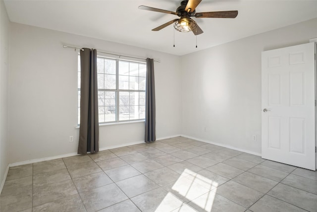 tiled spare room with ceiling fan