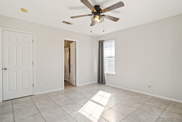 unfurnished bedroom with ceiling fan, connected bathroom, and light tile patterned floors