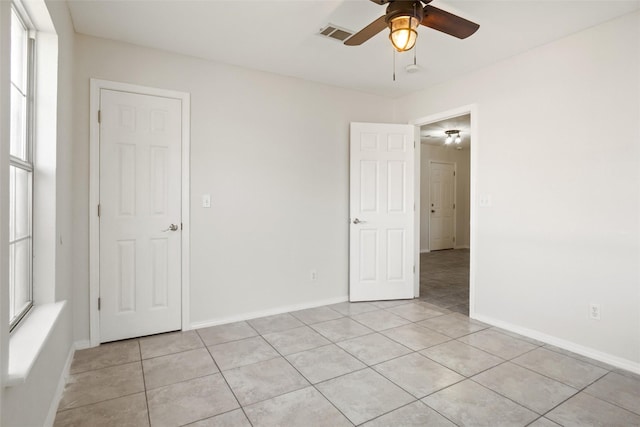 empty room featuring ceiling fan and light tile patterned flooring