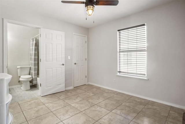 interior space featuring light tile patterned flooring, ceiling fan, connected bathroom, and multiple windows