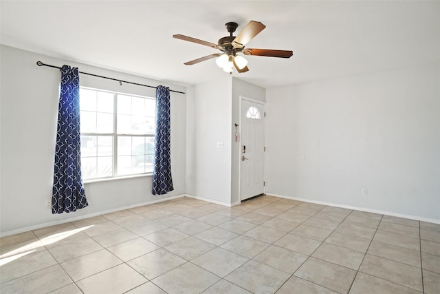 tiled empty room featuring ceiling fan