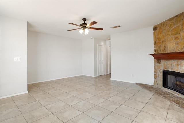 unfurnished living room with ceiling fan, light tile patterned floors, and a fireplace