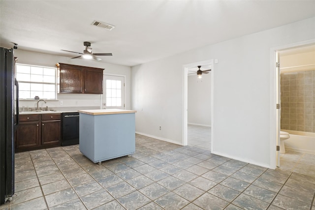 kitchen with dark brown cabinets, ceiling fan, sink, a center island, and black appliances