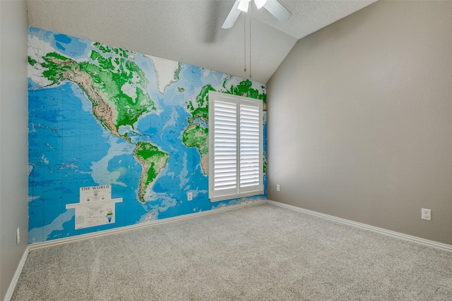 unfurnished room with carpet flooring, a textured ceiling, vaulted ceiling, and ceiling fan