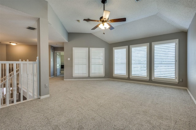 unfurnished room with ceiling fan, light colored carpet, a textured ceiling, and lofted ceiling