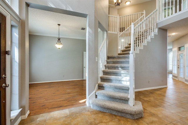 stairs with crown molding, tile patterned floors, and french doors