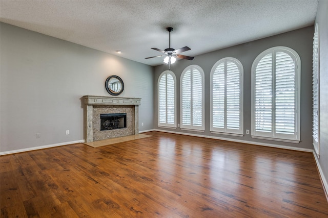 unfurnished living room featuring plenty of natural light, a textured ceiling, and a premium fireplace