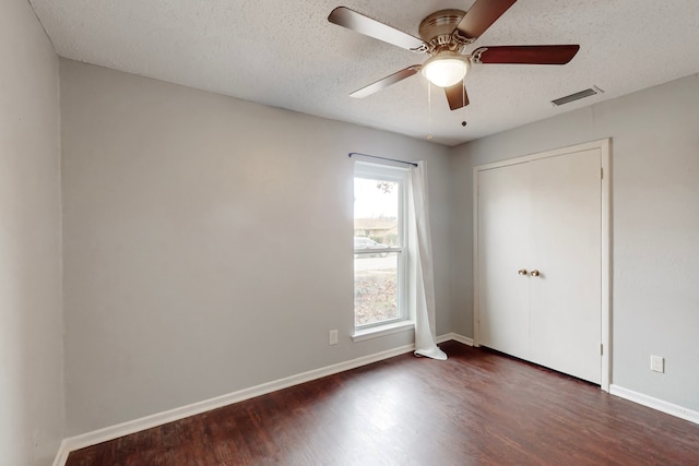1721 Melrose St, Garland, TX 75042 - unfurnished bedroom featuring dark wood-style flooring, a textured ceiling, and ceiling fan