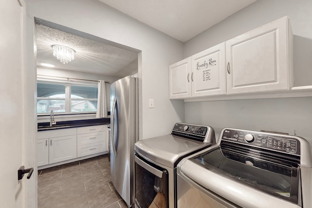 1721 Melrose St, Garland, TX 75042 - clothes washing area with a textured ceiling, a notable chandelier, washing machine and dryer, and a sink