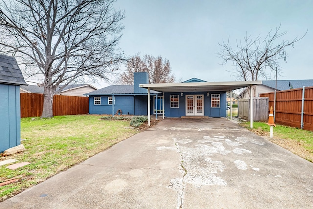 back of property with a lawn and french doors