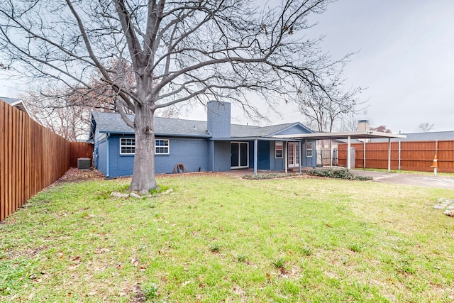 back of house featuring cooling unit, a yard, and a carport