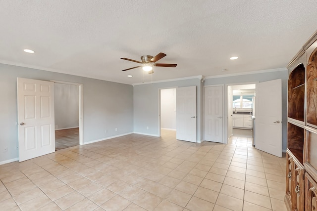 tiled spare room featuring crown molding, ceiling fan, and a textured ceiling