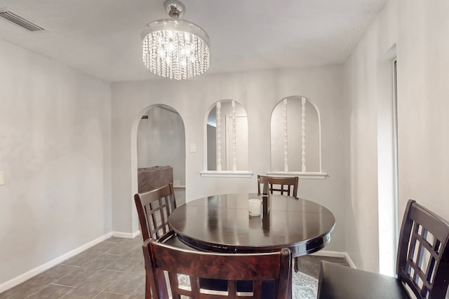 1721 Melrose St, Garland, TX 75042 - dining area featuring baseboards, arched walkways, visible vents, and a chandelier