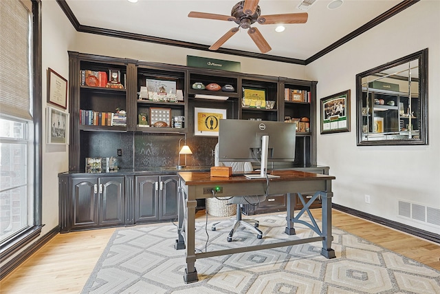 home office with ornamental molding, a healthy amount of sunlight, and light wood-type flooring