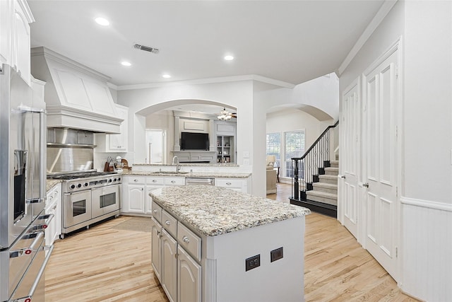 kitchen featuring sink, stainless steel appliances, a center island, tasteful backsplash, and white cabinets