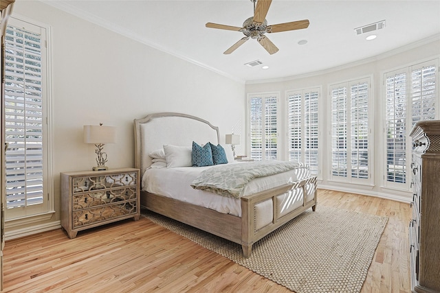 bedroom with crown molding, ceiling fan, multiple windows, and light hardwood / wood-style flooring