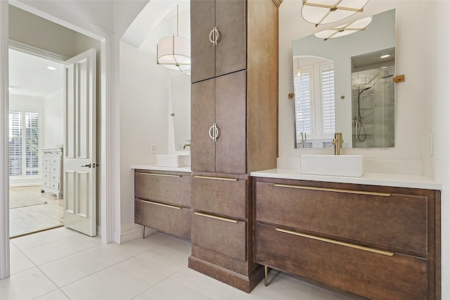 bathroom featuring tile patterned flooring, vanity, and a shower