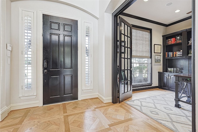 foyer featuring crown molding and light parquet flooring