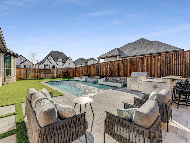 view of swimming pool featuring exterior kitchen, a patio, pool water feature, and a grill