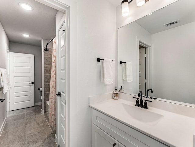 bathroom with walk in shower, vanity, and toilet