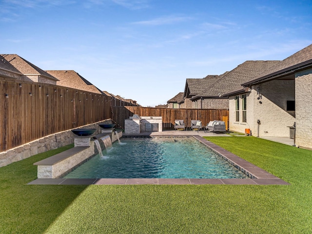 view of pool with pool water feature, area for grilling, a yard, and a patio