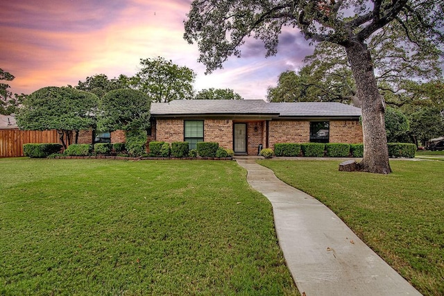 ranch-style home with a lawn