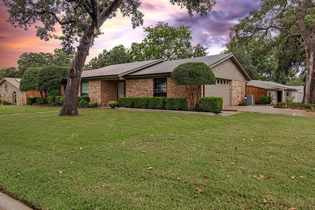 single story home with a garage, cooling unit, and a lawn