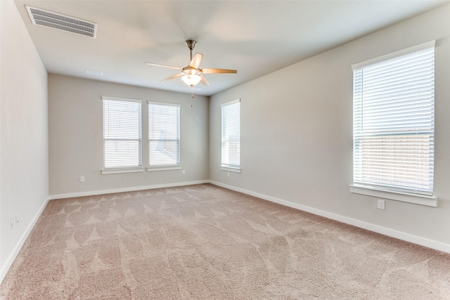 carpeted spare room featuring ceiling fan