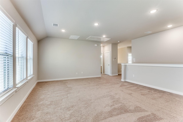 spare room with lofted ceiling and light carpet